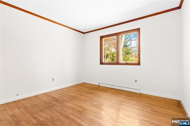 spare room featuring baseboard heating, light wood-style flooring, baseboards, and ornamental molding