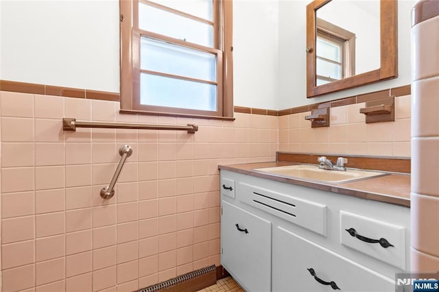 bathroom with wainscoting, vanity, and tile walls