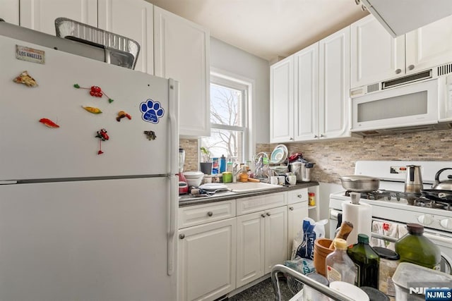 kitchen with white cabinetry, white appliances, and decorative backsplash