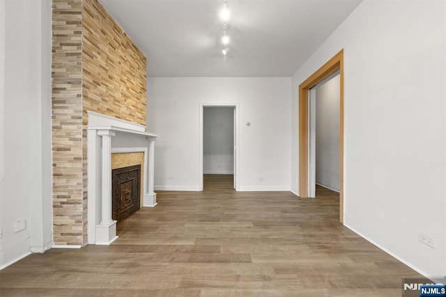 unfurnished living room featuring hardwood / wood-style flooring and a tile fireplace