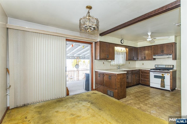 kitchen featuring dark brown cabinetry, sink, white gas range oven, decorative light fixtures, and ceiling fan with notable chandelier