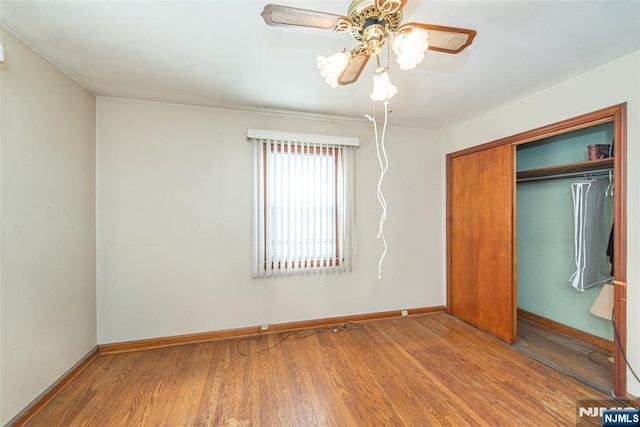 unfurnished bedroom with hardwood / wood-style floors, a closet, and ceiling fan