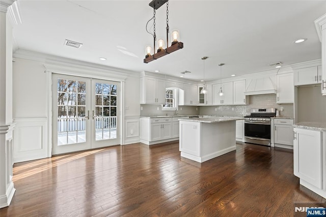 kitchen with premium range hood, pendant lighting, white cabinetry, gas range, and french doors