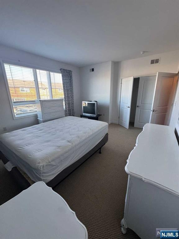 bedroom featuring light colored carpet and a closet