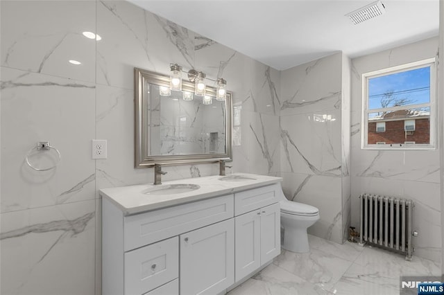 bathroom with radiator, vanity, and toilet