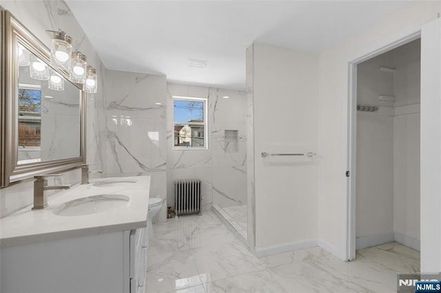 bathroom with radiator heating unit, a shower, vanity, and toilet