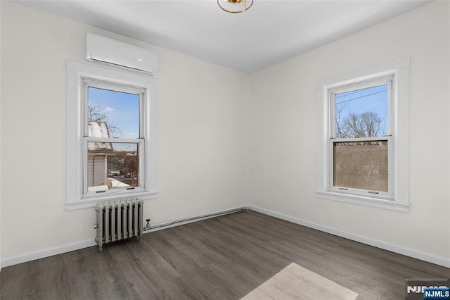 empty room with radiator heating unit, a wealth of natural light, dark hardwood / wood-style flooring, and a wall mounted AC