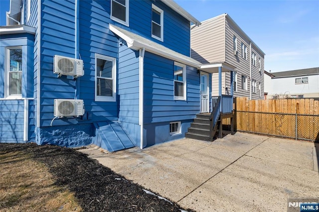 view of home's exterior with a patio area, ac unit, and a wall mounted air conditioner