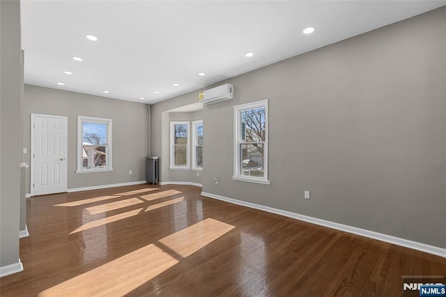 interior space featuring an AC wall unit and dark hardwood / wood-style floors