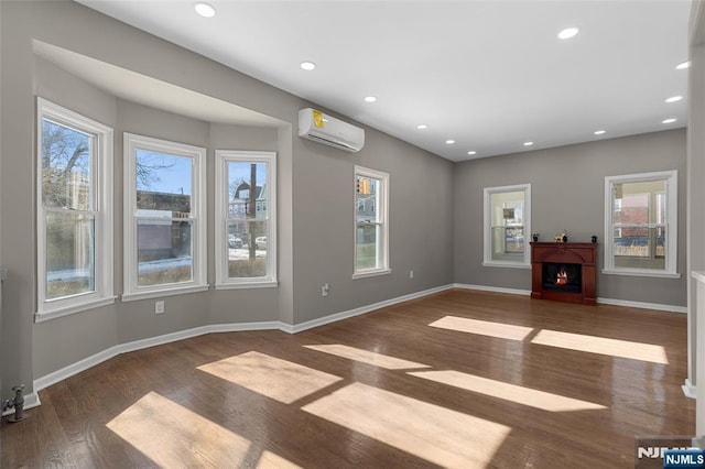 unfurnished living room featuring dark hardwood / wood-style flooring and a wall unit AC