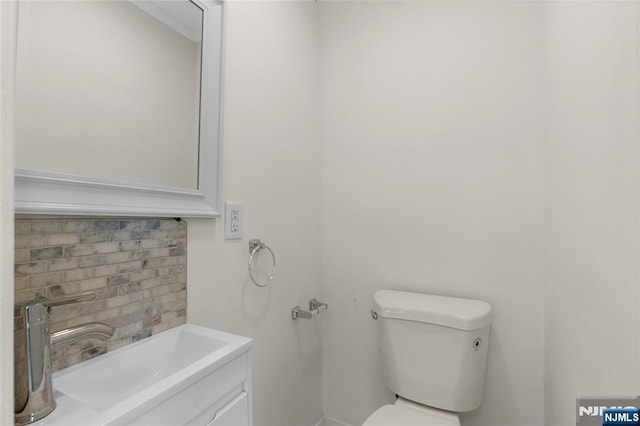 bathroom featuring backsplash, vanity, and toilet