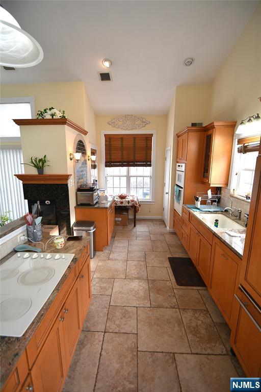 kitchen with sink, a wealth of natural light, white cooktop, and backsplash
