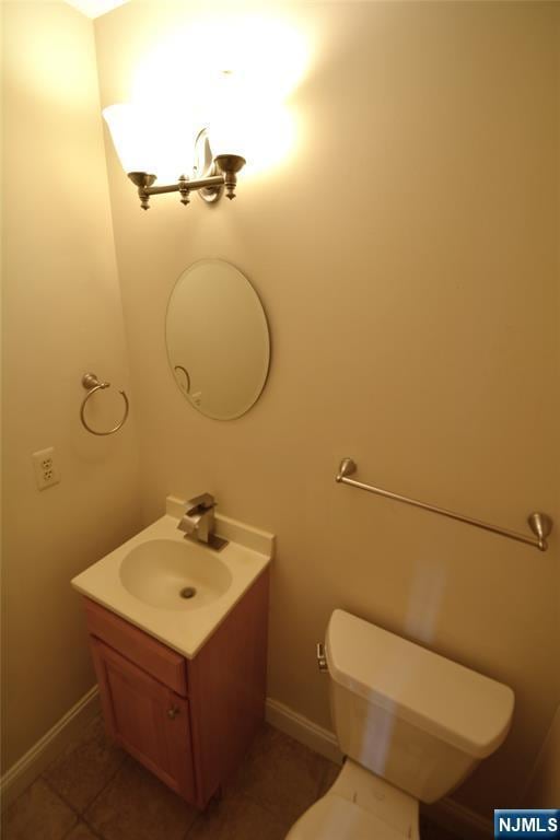 bathroom featuring vanity, toilet, and tile patterned flooring
