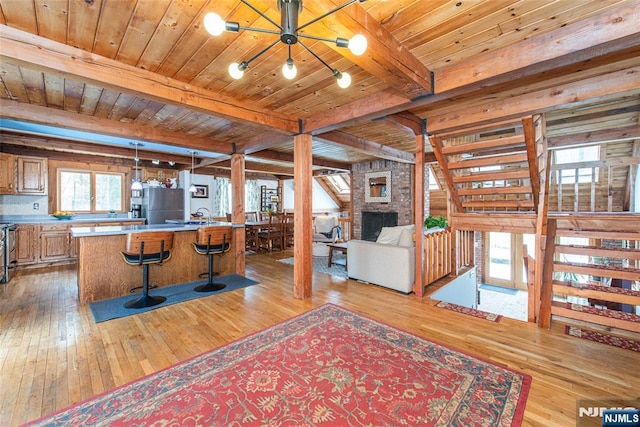 living room with wood ceiling, beamed ceiling, and light wood-type flooring