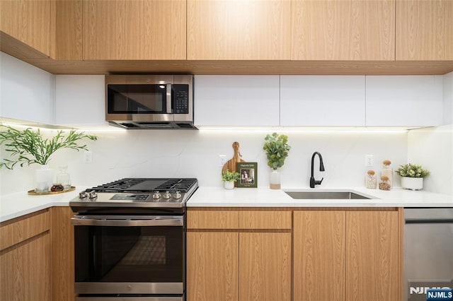 kitchen with stainless steel appliances, sink, and decorative backsplash