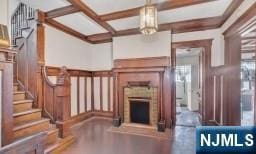 unfurnished living room with coffered ceiling and beam ceiling