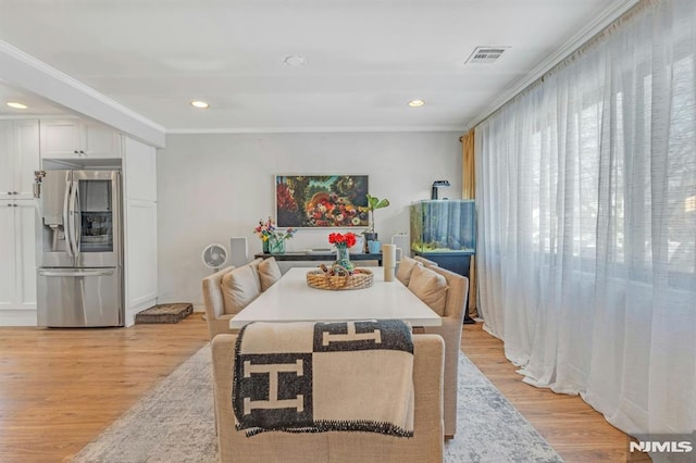 dining room featuring crown molding and light wood-type flooring