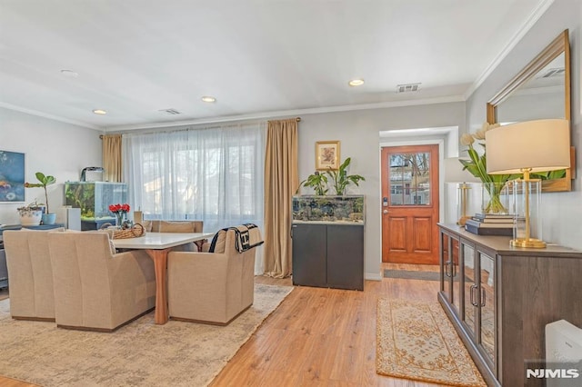 interior space with light hardwood / wood-style flooring and ornamental molding