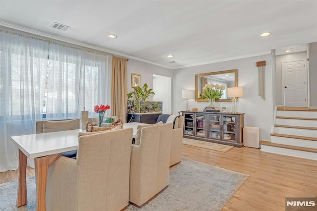 living room featuring crown molding and light hardwood / wood-style floors