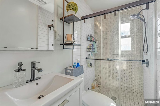 bathroom featuring vanity, an enclosed shower, and toilet