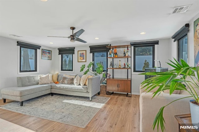 living room with ceiling fan and light hardwood / wood-style floors