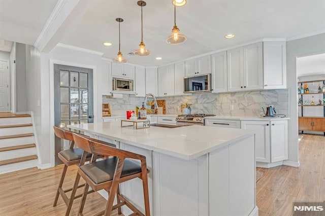 kitchen featuring appliances with stainless steel finishes, a breakfast bar area, and white cabinets