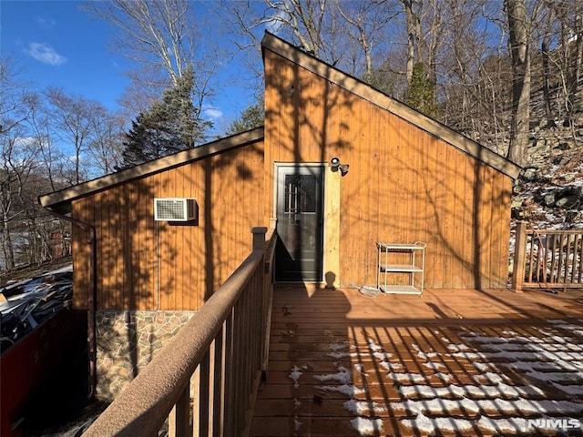 view of side of property featuring a wall mounted AC and a deck