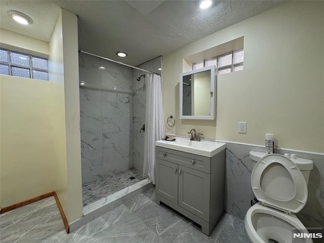 bathroom with vanity, toilet, plenty of natural light, a textured ceiling, and a shower with curtain