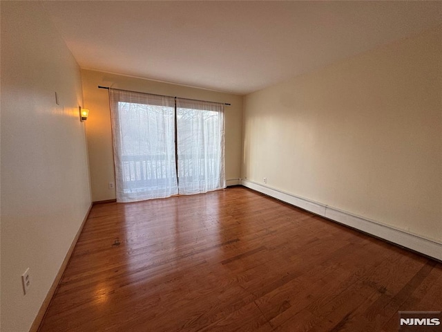 spare room with hardwood / wood-style floors and baseboard heating