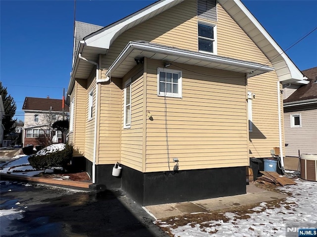 view of snowy exterior featuring cooling unit