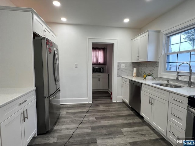 kitchen with stainless steel appliances, sink, and white cabinets