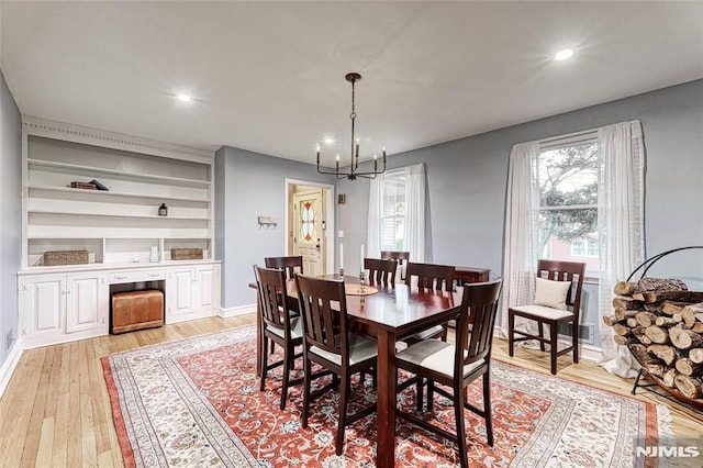 dining room featuring a notable chandelier, light hardwood / wood-style flooring, and a healthy amount of sunlight