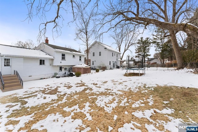 snow covered property featuring a trampoline