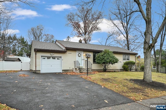 ranch-style house with a garage and a front lawn