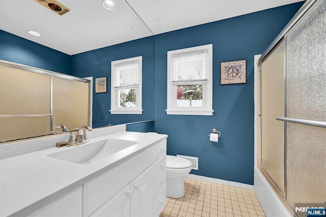 full bathroom featuring vanity, toilet, tile patterned flooring, and combined bath / shower with glass door