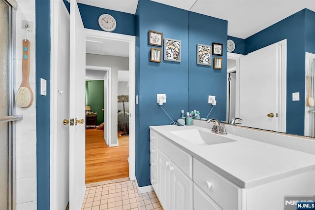 bathroom featuring tile patterned flooring, vanity, and a shower with door