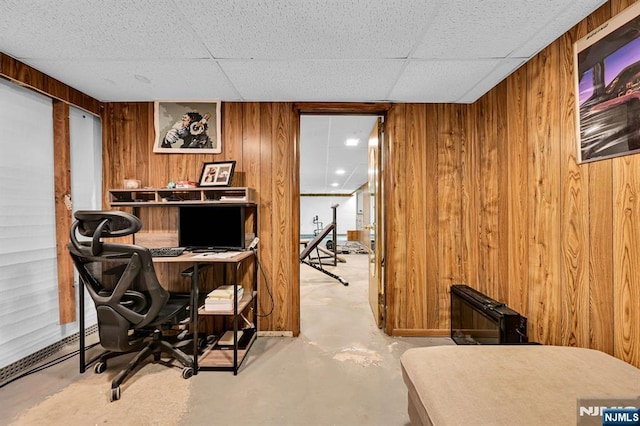 office with a drop ceiling and wooden walls