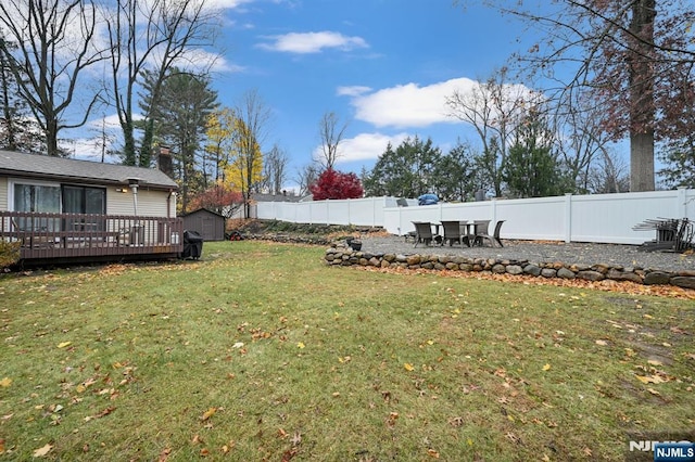 view of yard featuring a deck and a shed