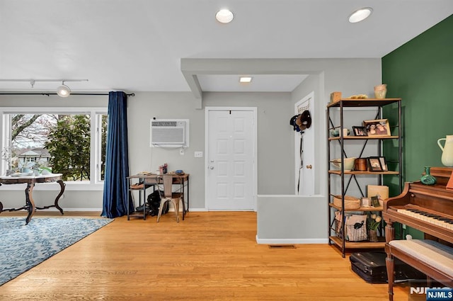 entryway featuring rail lighting, a wall mounted AC, and light hardwood / wood-style floors