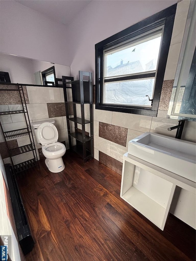 bathroom featuring hardwood / wood-style flooring, vanity, tile walls, and toilet