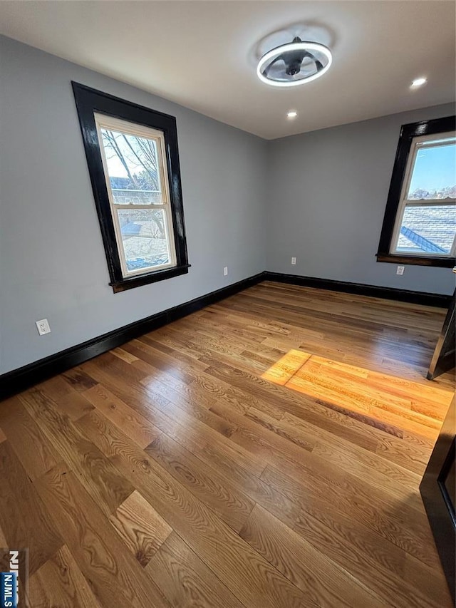 spare room with hardwood / wood-style flooring and plenty of natural light