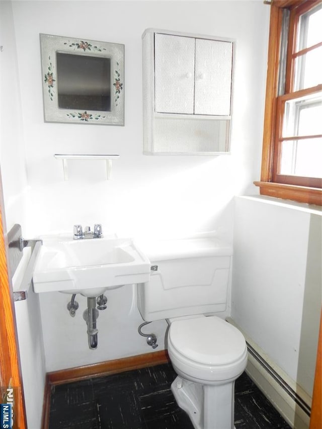 bathroom with a sink, toilet, and a baseboard radiator