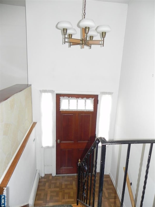 foyer entrance with a notable chandelier and a baseboard radiator