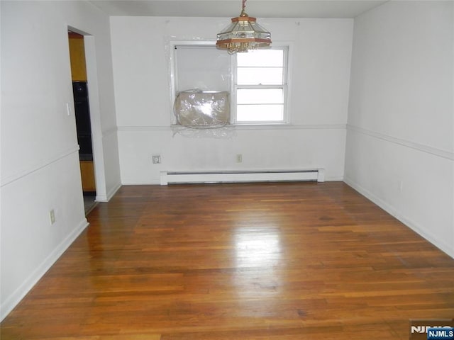 empty room with baseboards, wood finished floors, an inviting chandelier, and a baseboard radiator