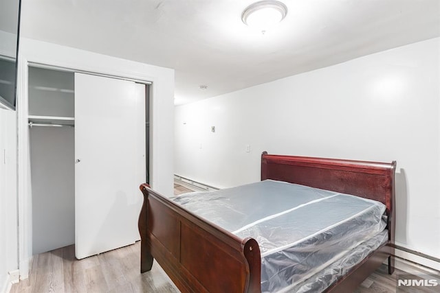 bedroom with light hardwood / wood-style floors and a closet