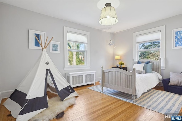 bedroom featuring radiator and wood finished floors