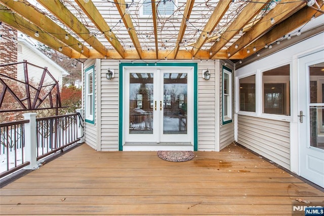 wooden terrace with a pergola and french doors