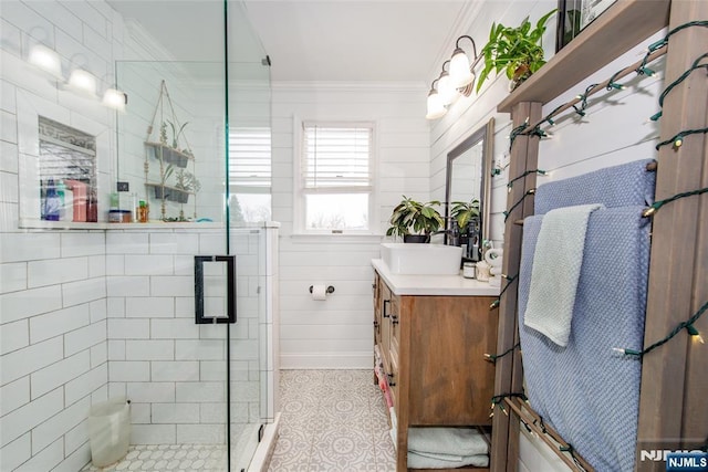 bathroom with an enclosed shower, vanity, and crown molding