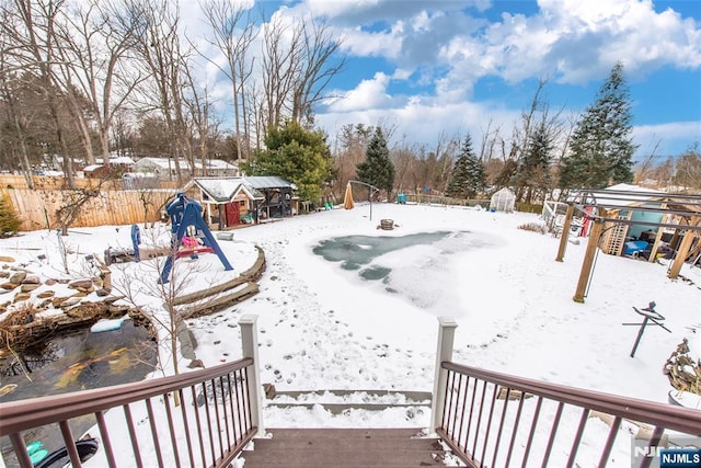 yard covered in snow featuring a playground