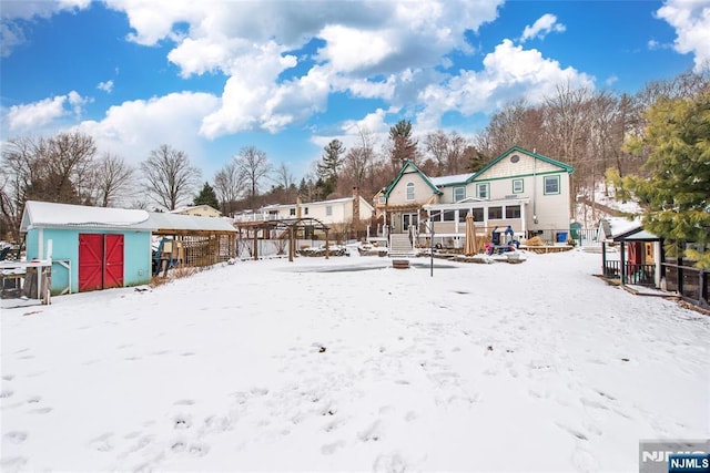 view of snow covered back of property